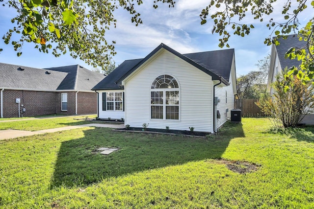 back of property with a yard and central AC unit