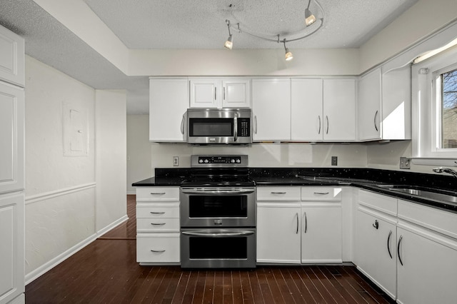 kitchen featuring appliances with stainless steel finishes, sink, and white cabinets