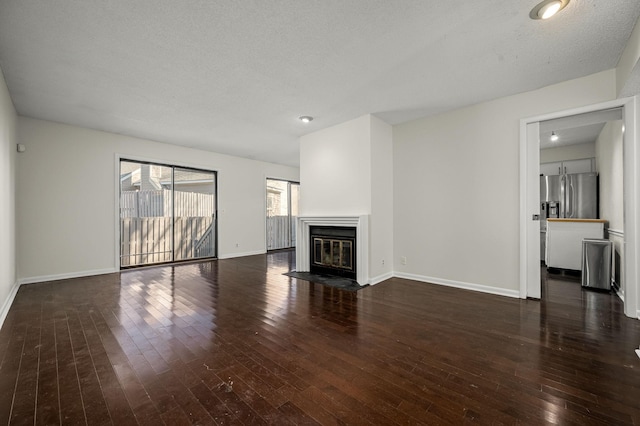 unfurnished living room with dark hardwood / wood-style floors and a textured ceiling