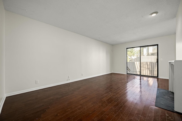 spare room with dark wood-type flooring and a textured ceiling