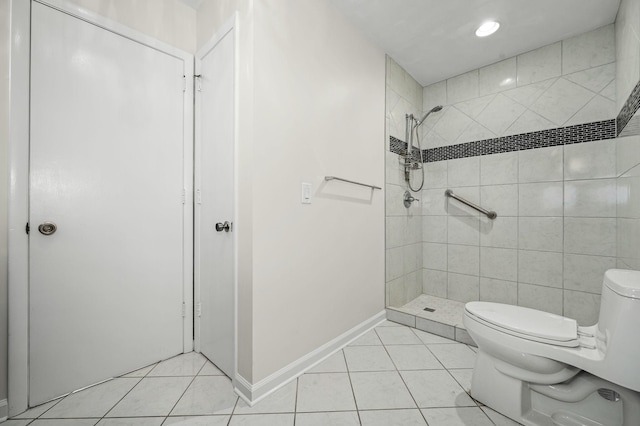 bathroom with a tile shower, tile patterned floors, and toilet