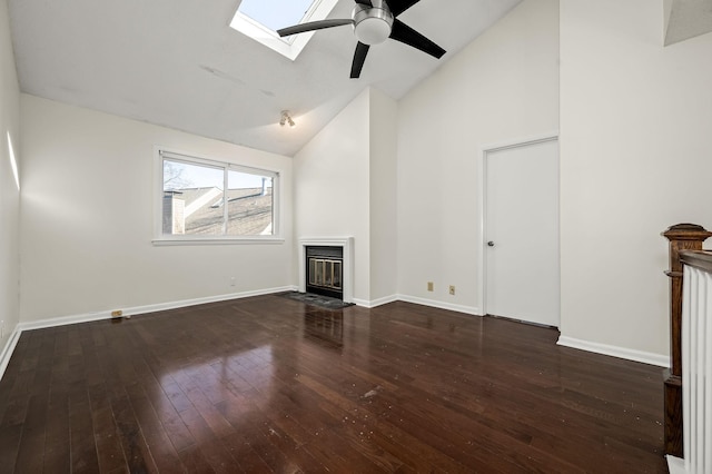 unfurnished living room with dark hardwood / wood-style floors, ceiling fan, and vaulted ceiling with skylight