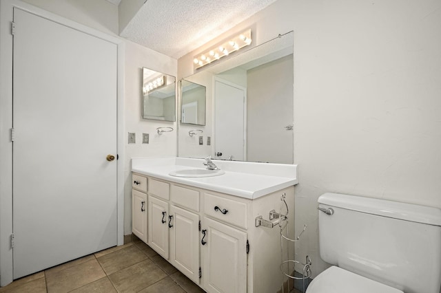 bathroom with vanity, tile patterned floors, a textured ceiling, and toilet