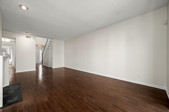 unfurnished living room featuring dark hardwood / wood-style flooring and a textured ceiling