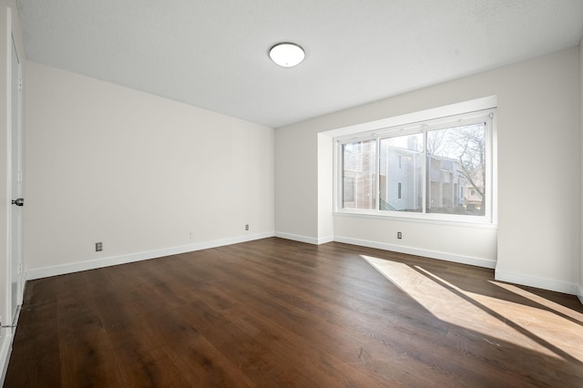 spare room with dark hardwood / wood-style floors