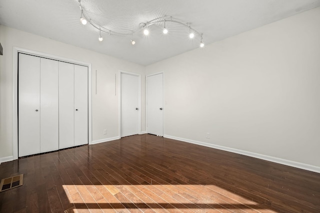 unfurnished bedroom with dark hardwood / wood-style floors, a textured ceiling, and a closet