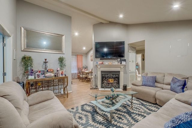 living room featuring vaulted ceiling with beams and light hardwood / wood-style flooring