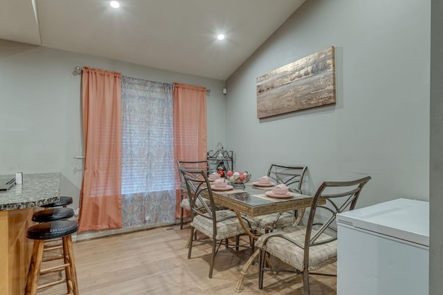 dining area featuring light hardwood / wood-style flooring and vaulted ceiling