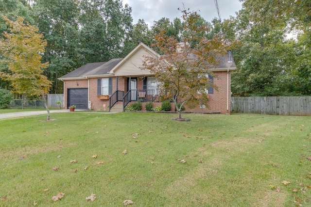 view of front of house featuring covered porch, a front yard, and a garage