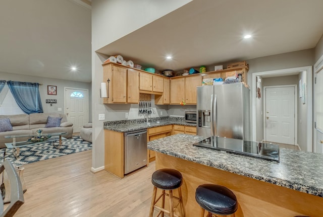 kitchen featuring sink, light brown cabinets, stainless steel appliances, light hardwood / wood-style flooring, and dark stone counters