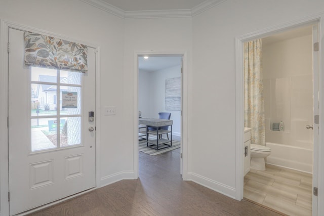 foyer featuring crown molding, hardwood / wood-style floors, and a healthy amount of sunlight