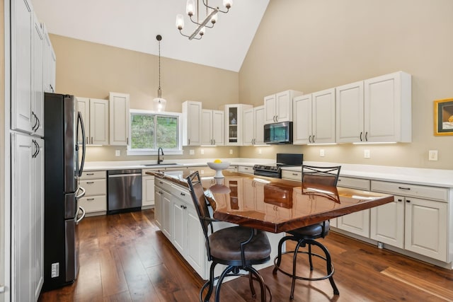 kitchen featuring sink, a kitchen island, high vaulted ceiling, white cabinets, and appliances with stainless steel finishes