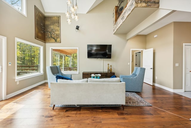 living room with a towering ceiling and wood-type flooring