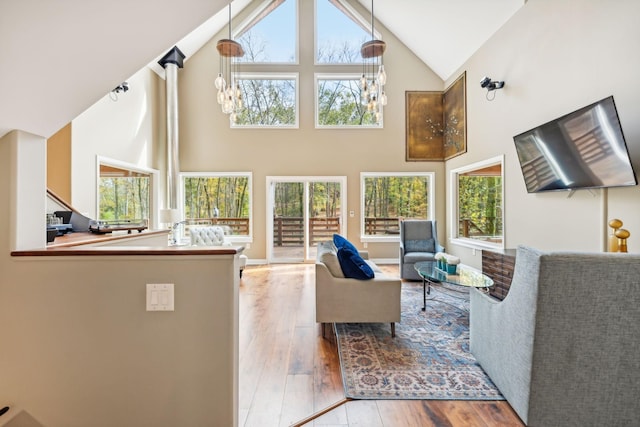 living room with high vaulted ceiling, a chandelier, and hardwood / wood-style flooring