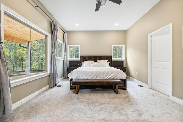 carpeted bedroom with multiple windows and ceiling fan