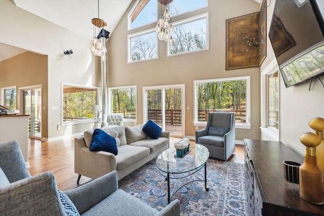 living room featuring hardwood / wood-style floors, a towering ceiling, and an inviting chandelier