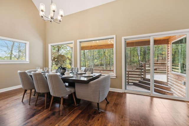 dining room with dark hardwood / wood-style flooring, a high ceiling, and a notable chandelier