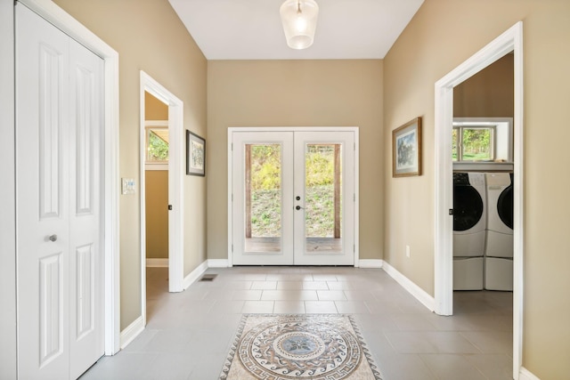 doorway featuring independent washer and dryer, french doors, a healthy amount of sunlight, and light tile patterned flooring