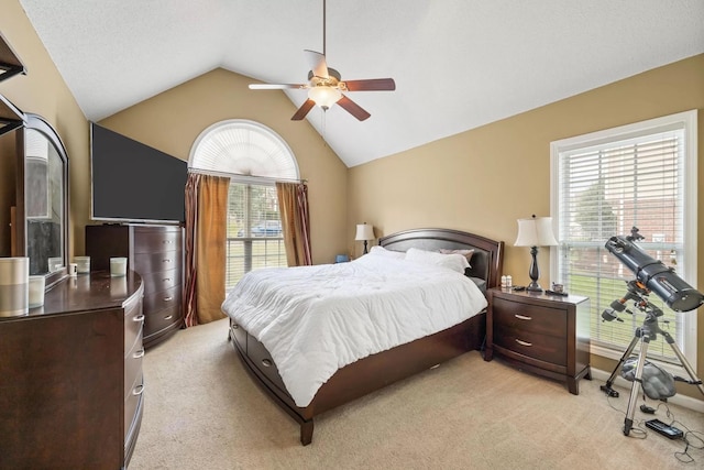 carpeted bedroom with multiple windows, ceiling fan, and vaulted ceiling