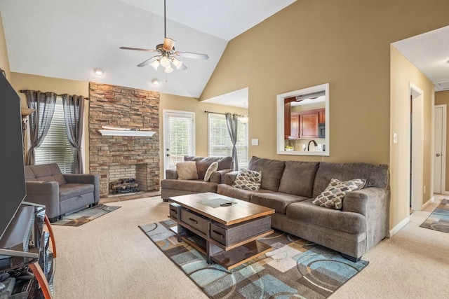 living room with light carpet, high vaulted ceiling, ceiling fan, and a fireplace