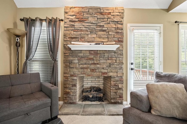 living room featuring a stone fireplace and lofted ceiling