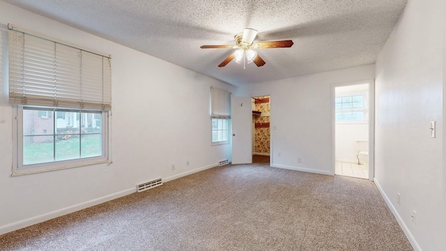 spare room featuring carpet flooring, a textured ceiling, and ceiling fan