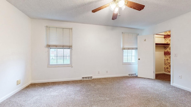 unfurnished bedroom featuring carpet, a textured ceiling, and ceiling fan