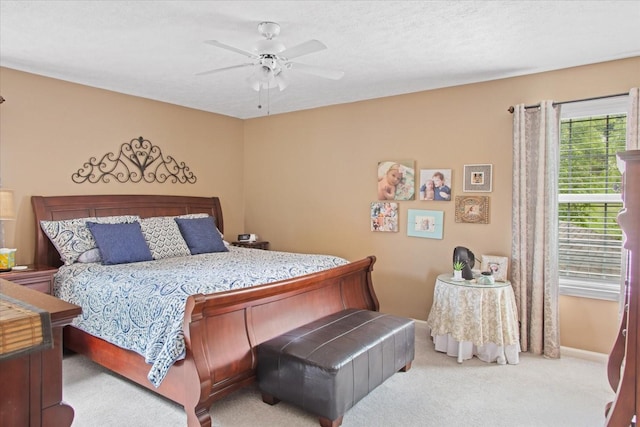 bedroom featuring a textured ceiling, ceiling fan, and light carpet