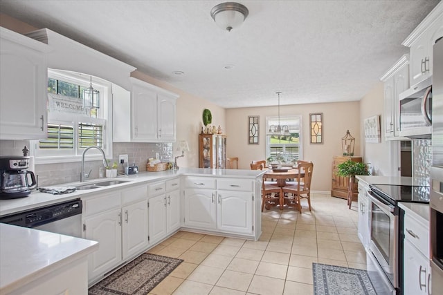 kitchen featuring kitchen peninsula, appliances with stainless steel finishes, white cabinets, and tasteful backsplash