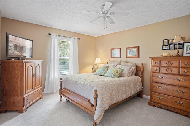 carpeted bedroom featuring ceiling fan and a textured ceiling