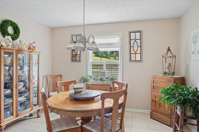 tiled dining room with a textured ceiling and a notable chandelier