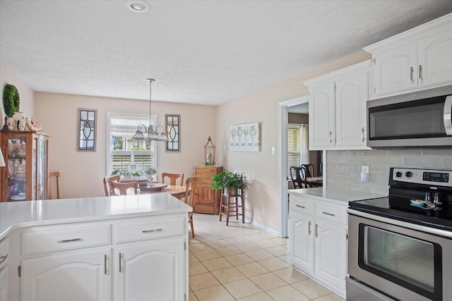 kitchen with white cabinetry, tasteful backsplash, a chandelier, pendant lighting, and appliances with stainless steel finishes