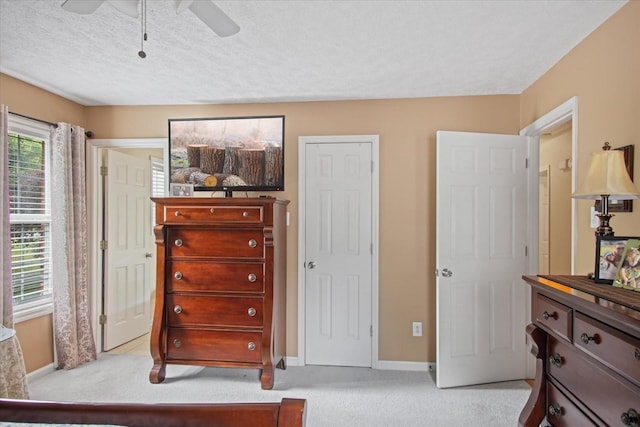 carpeted bedroom with a textured ceiling and ceiling fan