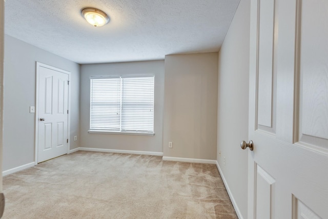 carpeted empty room featuring a textured ceiling