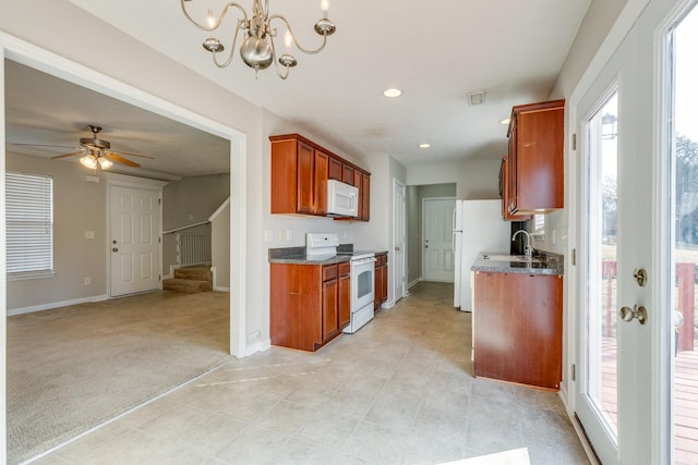 kitchen with ceiling fan with notable chandelier, light colored carpet, and white appliances