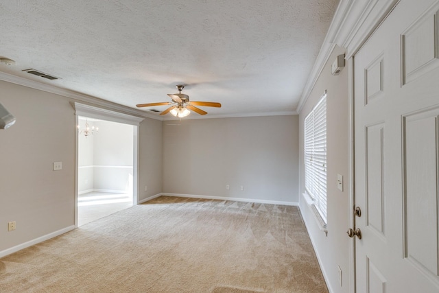 carpeted spare room featuring a textured ceiling, ceiling fan with notable chandelier, and crown molding