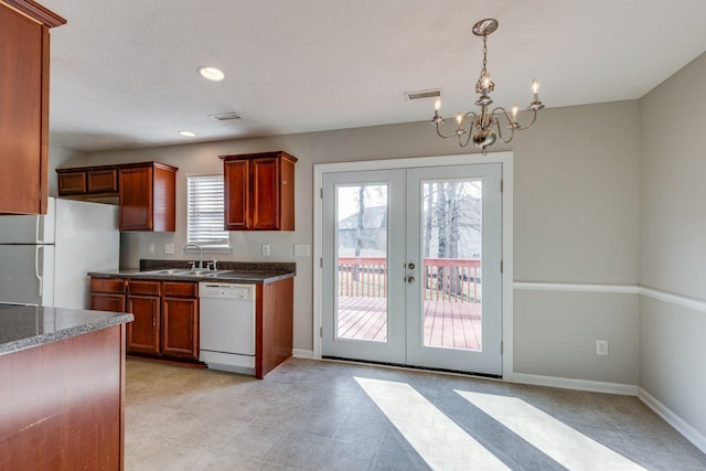 kitchen with french doors, white appliances, a healthy amount of sunlight, and a notable chandelier