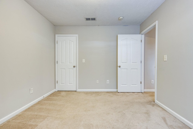 carpeted empty room with a textured ceiling