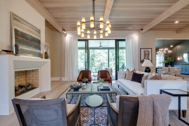 living room featuring ceiling fan with notable chandelier, beam ceiling, light wood-type flooring, and wood ceiling