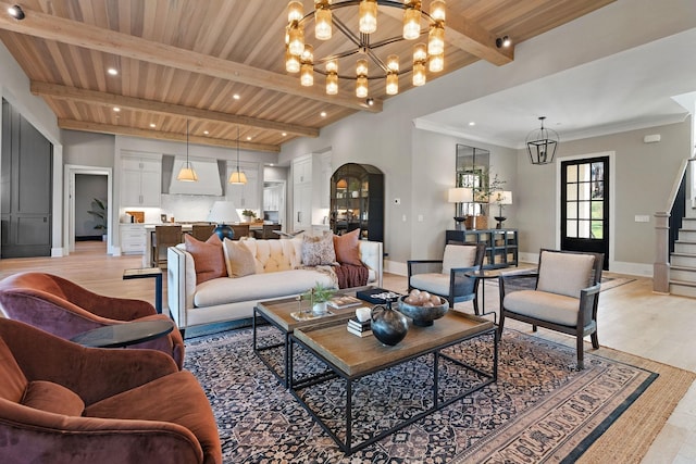 living room featuring beam ceiling, wood ceiling, light hardwood / wood-style flooring, and a chandelier