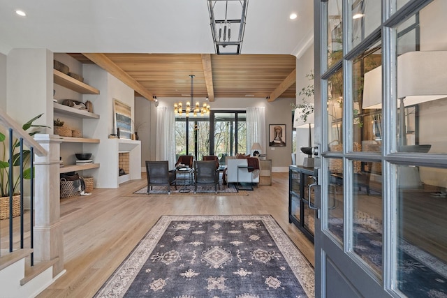 interior space featuring beam ceiling, light hardwood / wood-style flooring, wooden ceiling, and a notable chandelier