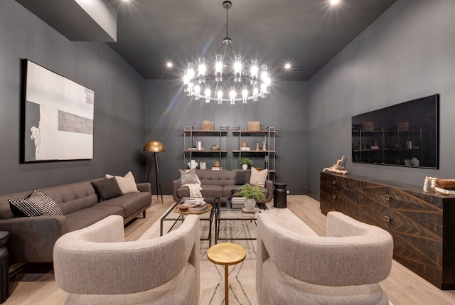 living room with a notable chandelier, light wood-type flooring, and a high ceiling