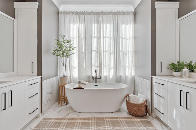 bathroom with a bathing tub, vanity, and crown molding