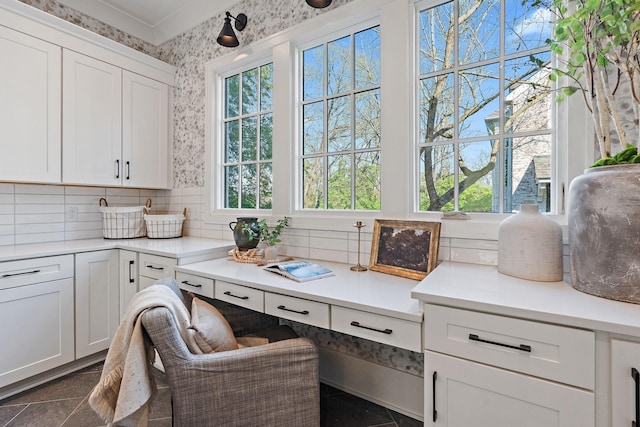 kitchen with a wealth of natural light, white cabinetry, and dark tile patterned flooring