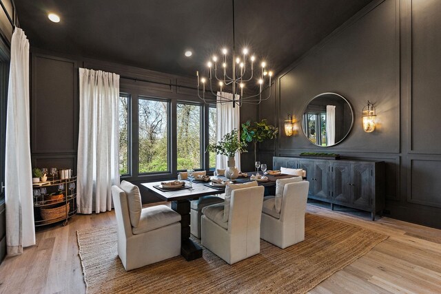 dining area with light hardwood / wood-style flooring and an inviting chandelier