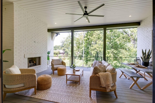 sunroom with an outdoor brick fireplace and ceiling fan