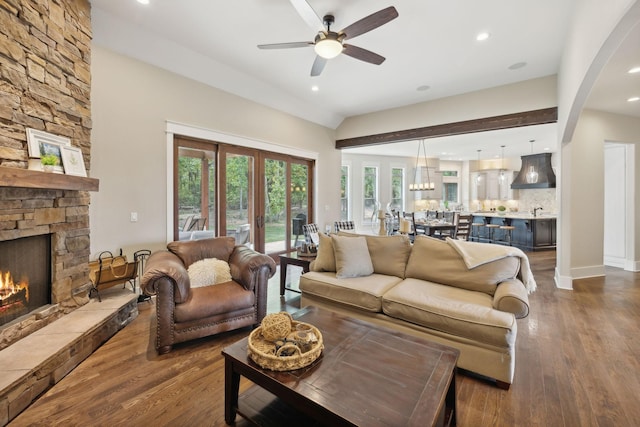 living room featuring a fireplace, wood-type flooring, ceiling fan, and lofted ceiling