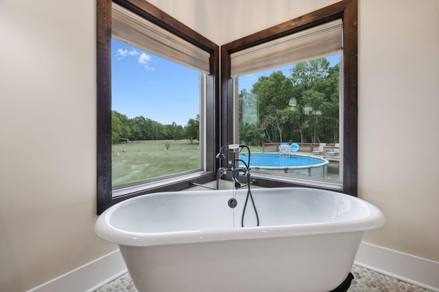 bathroom with a washtub and tile patterned flooring