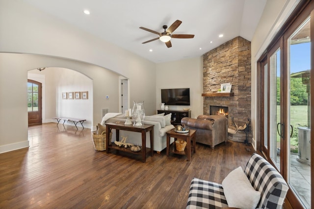 living room with dark hardwood / wood-style flooring, ceiling fan, a fireplace, and plenty of natural light