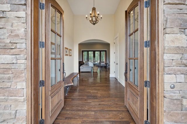 foyer with french doors, dark hardwood / wood-style floors, and an inviting chandelier